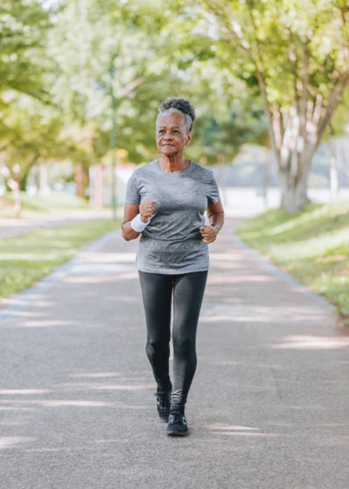 african american lady jogging in park from prp therapy